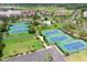 Aerial view showcasing multiple tennis courts and an outdoor pool area in a community at 417 S Dunes Dr., Pawleys Island, SC 29585