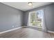 Bedroom featuring wood-look floors, gray walls, and a window with sheer white curtains at 4197 Friendfield Trace, Little River, SC 29566