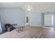Living room with vaulted ceiling, wood floors, blue walls, a ceiling fan, and an entry doorway on the right at 4197 Friendfield Trace, Little River, SC 29566