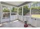 Enclosed porch with view of greenery and tile flooring at 4197 Friendfield Trace, Little River, SC 29566