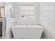 Modern soaking tub with a window view and elegant marble finishes at 496 West Palm Dr., Myrtle Beach, SC 29579