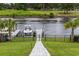 Home featuring a private boat dock on the waterway with a fenced yard and beautiful landscaping at 496 West Palm Dr., Myrtle Beach, SC 29579