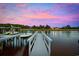 Picturesque waterfront view featuring a private dock, boat lift, and scenic sunset colors, ideal for enjoying water activities at 496 West Palm Dr., Myrtle Beach, SC 29579