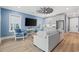 Cozy living room with light blue walls, light wood floors, and white kitchen cabinets with stainless steel refrigerator at 496 West Palm Dr., Myrtle Beach, SC 29579