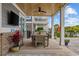 Covered patio space with dining table, ceiling fan, brick pillars, and serene outdoor views at 496 West Palm Dr., Myrtle Beach, SC 29579