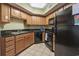 Functional kitchen features wooden cabinets, black countertops, and modern black appliances at 504 N Ocean Blvd. # 1901, Myrtle Beach, SC 29577