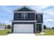 Two-story home showcases a modern design with a blue exterior, complemented by a two-car garage and well-manicured lawn at 540 Scarlet Sage Dr., Conway, SC 29527