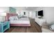 Bright main bedroom with white walls, luxury vinyl floors, pink bed and ocean decor at 5511 N Ocean Blvd. # 1603, Myrtle Beach, SC 29577