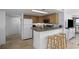 A quaint kitchen is shown with tile floor, wooden cabinets, granite counter, and a breakfast bar with seating at 5511 N Ocean Blvd. # 310, Myrtle Beach, SC 29577