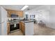 This eat-in kitchen includes wood cabinets, stainless steel appliances, and opens to living space with ocean views at 5511 N Ocean Blvd. # 310, Myrtle Beach, SC 29577