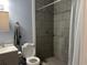 Bathroom with a toilet and shower, featuring modern gray tiling at 613 Todd Blvd., Conway, SC 29526