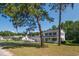 Attractive two-story home with blue shutters and an inviting front porch, set amidst lush landscaping at 66 Johnstone Ln., Georgetown, SC 29440