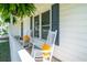 Inviting front porch with two white rocking chairs accented by yellow cushions, creating a cozy outdoor space at 66 Johnstone Ln., Georgetown, SC 29440