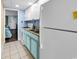 Bright kitchen with white and light blue cabinets, modern appliances, with access to bedroom and main door at 6900 N Ocean Blvd. # 1541, Myrtle Beach, SC 29572