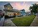 Charming yellow two-story home with a porch, white picket fence, and green lawn at 721 Mckinley Way, Myrtle Beach, SC 29577