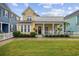 Charming two-story yellow home with a white picket fence and well-manicured landscaping at 721 Mckinley Way, Myrtle Beach, SC 29577