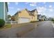 Yellow home featuring a two-car garage, white picket fence, and landscaping at 721 Mckinley Way, Myrtle Beach, SC 29577