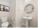 Cozy powder room featuring pedestal sink, toilet, and decorative mirror at 721 Mckinley Way, Myrtle Beach, SC 29577