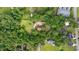 Aerial view of a property with lush greenery, a well-maintained lawn, and various structures surrounded by trees at 7288 Schooners Ct. Sw, Ocean Isle Beach, NC 28469