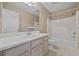 Neutral bathroom with a single sink vanity, a large mirror, and a combined tub and shower with a white surround at 7288 Schooners Ct. Sw, Ocean Isle Beach, NC 28469
