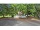 A charming home exterior with a white picket fence and mature trees, offering a secluded feel at 7288 Schooners Ct. Sw, Ocean Isle Beach, NC 28469