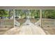 View from the covered front porch, showcasing the entryway and surrounding greenery at 7288 Schooners Ct. Sw, Ocean Isle Beach, NC 28469