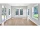 Sunlit dining area with hardwood floors, a modern chandelier, and large windows at 872 Fowler Rd., Conway, SC 29526
