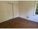 A vacant bedroom with hardwood floors, natural light, and a closet with bi-fold doors at 911 Park Ave., Marion, SC 29571