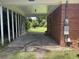 View of the carport highlighting the brick exterior of the home and view of the spacious yard at 911 Park Ave., Marion, SC 29571