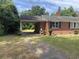 Exterior of the brick home highlighting the carport, brick chimney and landscaped front yard at 911 Park Ave., Marion, SC 29571