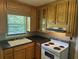 Cozy kitchen with wood cabinets, black countertops, and stainless-steel range hood at 911 Park Ave., Marion, SC 29571