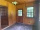 The sunroom features wood paneling, a light fixture, a window and a door leading to the outside at 911 Park Ave., Marion, SC 29571