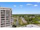 Elevated view showcasing a condo building, a lake, and lush greenery with distant neighborhood at 9994 Beach Club Dr. # 1202, Myrtle Beach, SC 29572