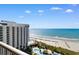 Beautiful beach view from a high-rise condo balcony showcasing the ocean, beach, and multiple pools at 9994 Beach Club Dr. # 1202, Myrtle Beach, SC 29572