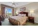 Cozy bedroom with a balcony view, floral bedding, lamps, and neutral-toned walls at 9994 Beach Club Dr. # 1202, Myrtle Beach, SC 29572