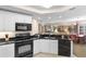Open kitchen with black appliances, white cabinets, and open view to dining and living areas at 9994 Beach Club Dr. # 1202, Myrtle Beach, SC 29572