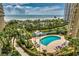 Resort-style pool area with palm trees, lounge chairs, and a view of the ocean beyond at 9994 Beach Club Dr. # 1202, Myrtle Beach, SC 29572