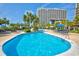 Inviting in-ground pool with lounge chairs and umbrellas, ideal for relaxation and enjoying the sun at this luxurious resort at 9994 Beach Club Dr. # 1202, Myrtle Beach, SC 29572