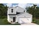 Charming two-story home featuring a two-car garage, and a manicured lawn with vibrant green grass at Lot 149 Tibetan St., Conway, SC 29526