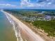 Stunning aerial view of coastline featuring oceanfront properties, sandy beaches, and beautiful waterways at 100 Ocean Park Loop, Georgetown, SC 29440