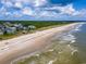Breathtaking aerial view of the coastline showcases beachfront homes and pristine sandy shores at 100 Ocean Park Loop, Georgetown, SC 29440