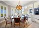 Open dining room with round table, ocean views, unique lighting, and view to the large living room with fireplace at 100 Ocean Park Loop, Georgetown, SC 29440