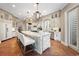 Elegant kitchen featuring a large island, pendant lights, custom cabinets, modern appliances, and terracotta-style floors at 100 Ocean Park Loop, Georgetown, SC 29440