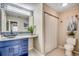 Charming bathroom with a decorative mirror, blue vanity, and a bright light fixture at 10056 Kings Rd., Myrtle Beach, SC 29572