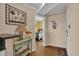 Hallway view of the home interior with wooden floors, a table with shell decor, and a peek into the bedroom at 101 W First St. # A2, Ocean Isle Beach, NC 28469