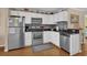 Well-equipped kitchen featuring stainless steel appliances, white cabinetry, and sleek black countertops at 101 W First St. # A2, Ocean Isle Beach, NC 28469