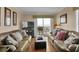 Spacious living room with comfortable seating, wooden floors, and a balcony overlooking the ocean at 101 W First St. # A2, Ocean Isle Beach, NC 28469
