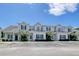 View of the townhomes with beige siding, blue shutters, and well-maintained landscaping at 105 Spring Creek Dr. # C, Myrtle Beach, SC 29588
