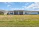 View of the backyard with a screen porch, grill and green grass, perfect for outdoor enjoyment at 1121 Oxeye St., North Myrtle Beach, SC 29582
