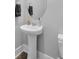 Bathroom with pedestal sink, modern fixtures, and oval mirror at 1121 Oxeye St., North Myrtle Beach, SC 29582